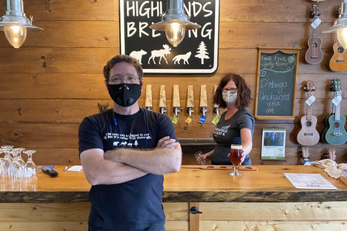 owner of Haliburton Highlands Brewing in front of bar