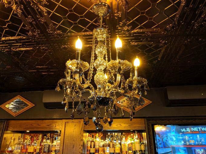 A chandelier hanging from the tin ceiling in Smith & Barrel