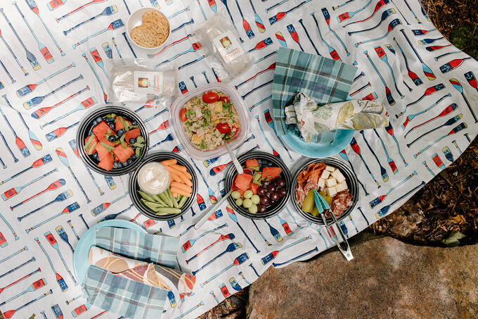 Food is displayed on a picnic blanket.