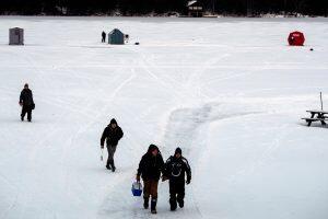 anglers walking along frozen lake