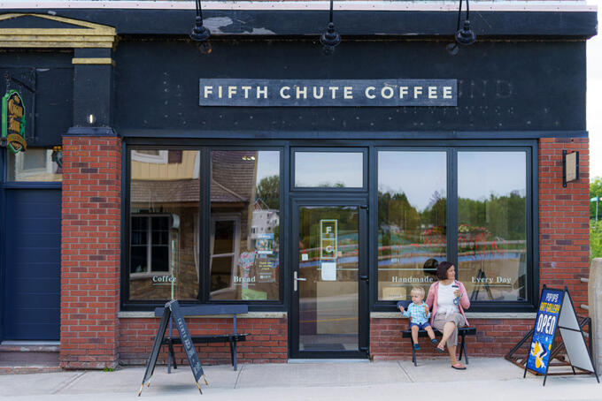 toddler and parent under Fifth Chute Coffee sign