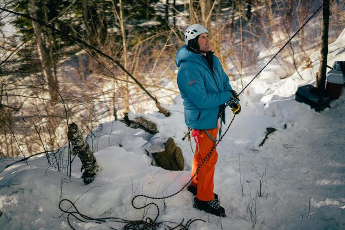 Lorne Foisy standing in forest, holding climbing rope