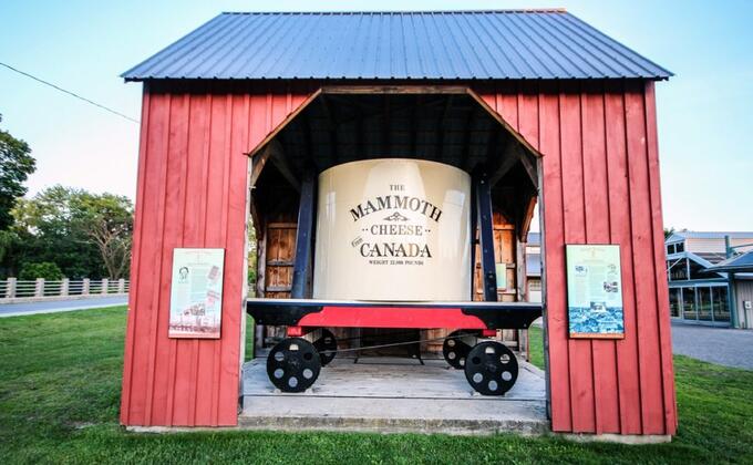 red tin shed with informational plaques harbouring a sign that reads "The Mammoth Cheese From Canada"