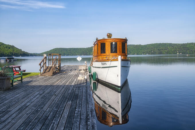 A boat sits in the water beside a dock.