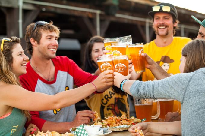 A group of people cheers with beer from Whitewater Brewing Co.