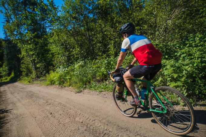 A man rides a bicycle on a rural trail.