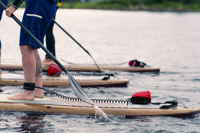 A woman stands on a stand up paddleboard