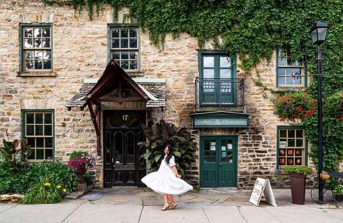 Girl in a poofy white dress standing in front of an old building with stone brick