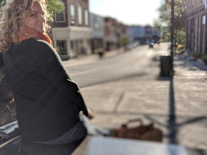 A woman sitting on a bench outdoors.