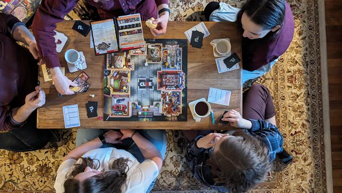 A group of people play a board game.